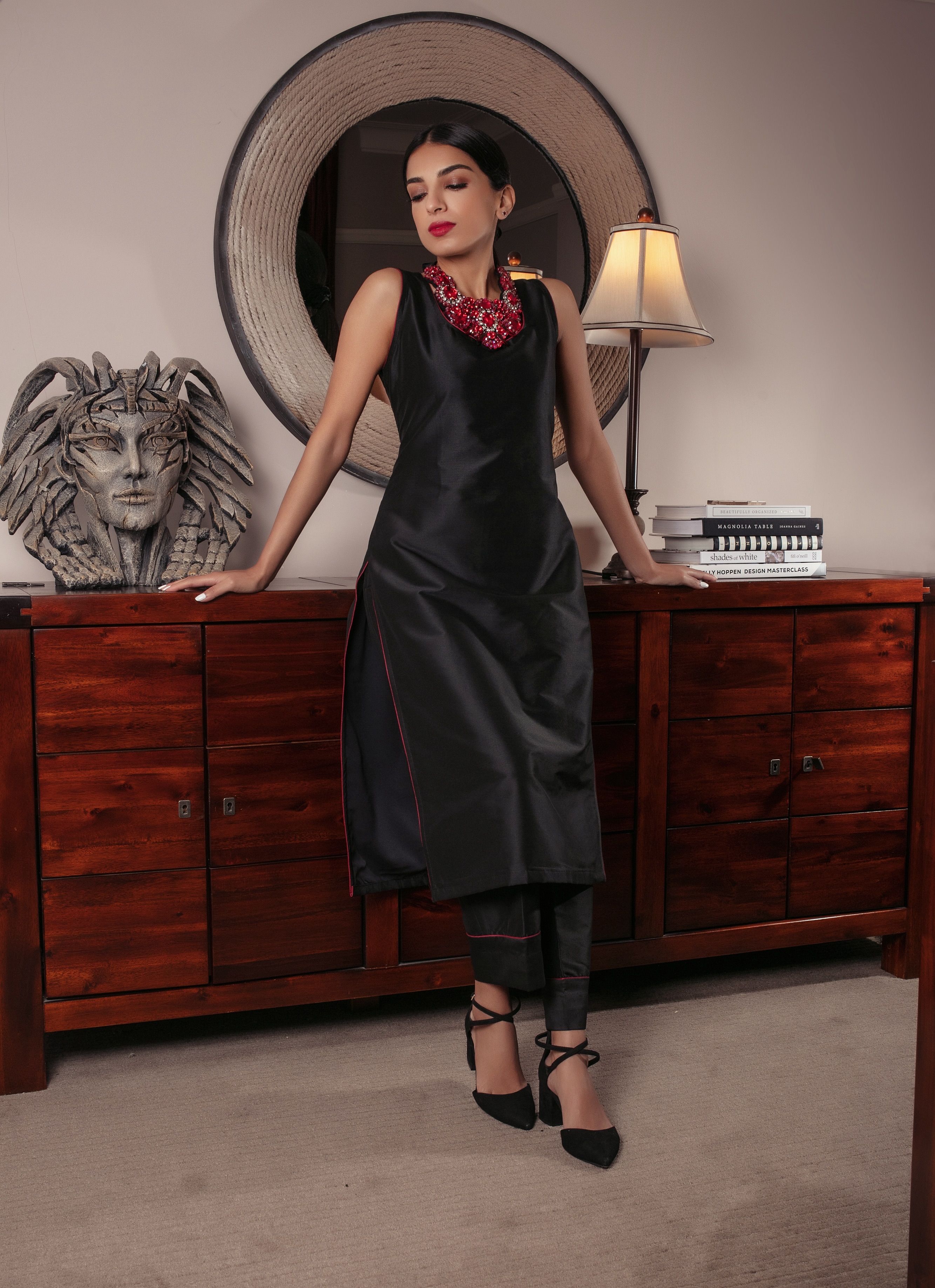 A classy black silk top with red piping paired with black silk pants with red piping